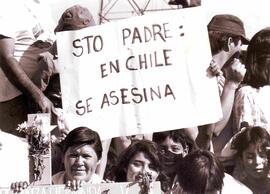 Personas yendo a ver al papa, con carteles que dicen Sto. Padre: En Chile se asesina