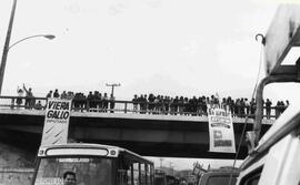 Puente con varias personas, del cual cuelgan lienzos de la concertación, a favor de Aylwin y Vier...