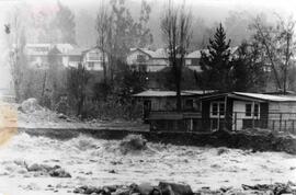 Casas al lado de un río que lleva una corriente