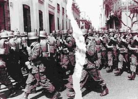 Soldados desfilan frente al palacio de La Moneda (la foto presenta un desgarro gráfico al centro)