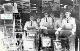 Niños trabajadores de supermercado, posando para la cámara con carros y sus uniformes