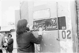 Letelier, Juan Pablo poniendo en un muro, una imagen con el nombre de su padre y el símbolo del PS