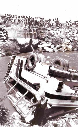 Accidentes: Micro volcada dentro de un canal, mientras la gente mira desde lejos el accidente