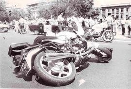 Motocicleta rota en el suelo, tras accidente y carabineros y público, observando