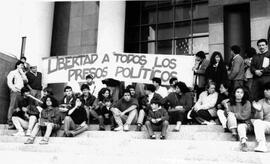 Grupo de manifestantes despliegan lienzo, con la leyenda Libertad a todos los presos políticos, e...