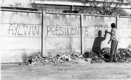 Joven, haciendo un rayado con spray en un muro, para hacerle propaganda a Patricio Aylwin